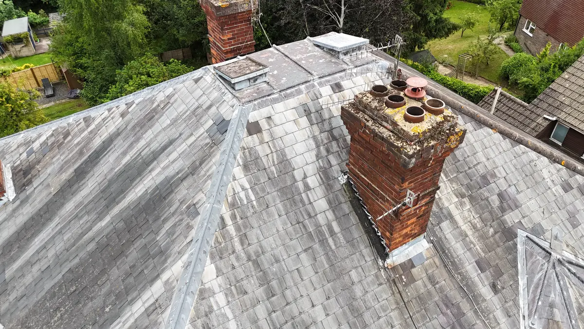 Drone aerial inspection showing aged slate roof and chimney condition