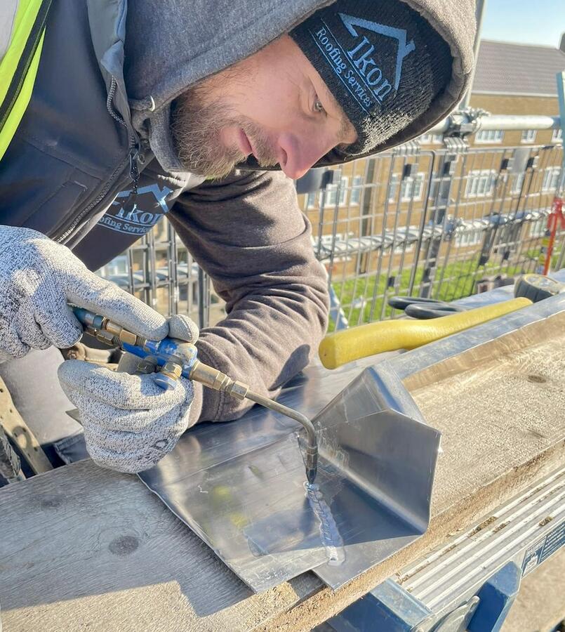 Jordan from Ikon Roofing welding lead in branded workwear
